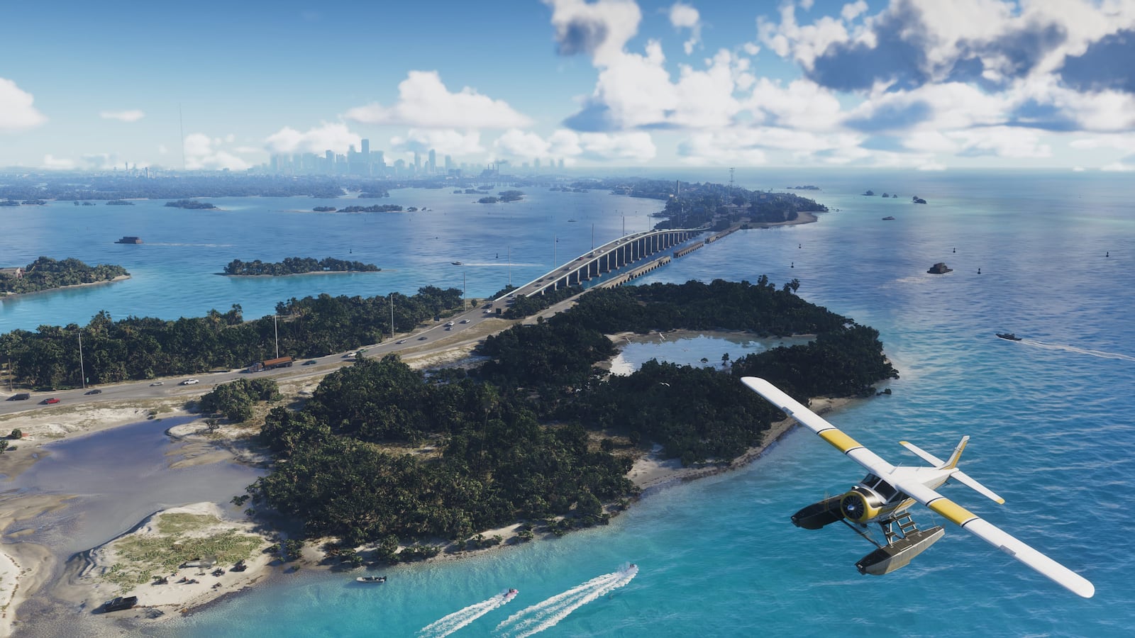 A seaplane above low islands, blue water and a long causeway