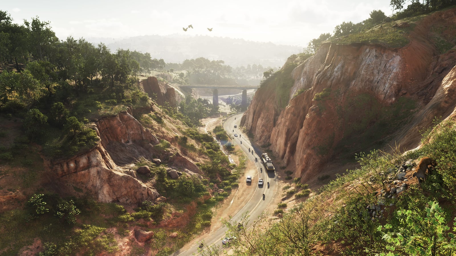 A road and bridge passing through a steep wooded red-rock cut