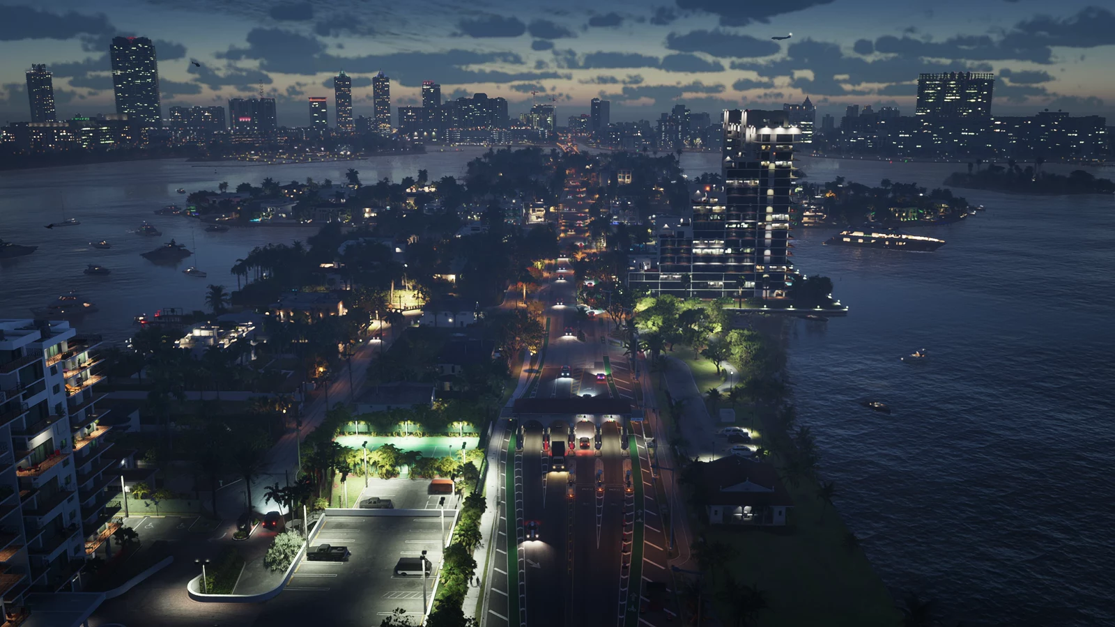 An illuminated road on a narrow waterfront corridor with the Vice City skyline beyond