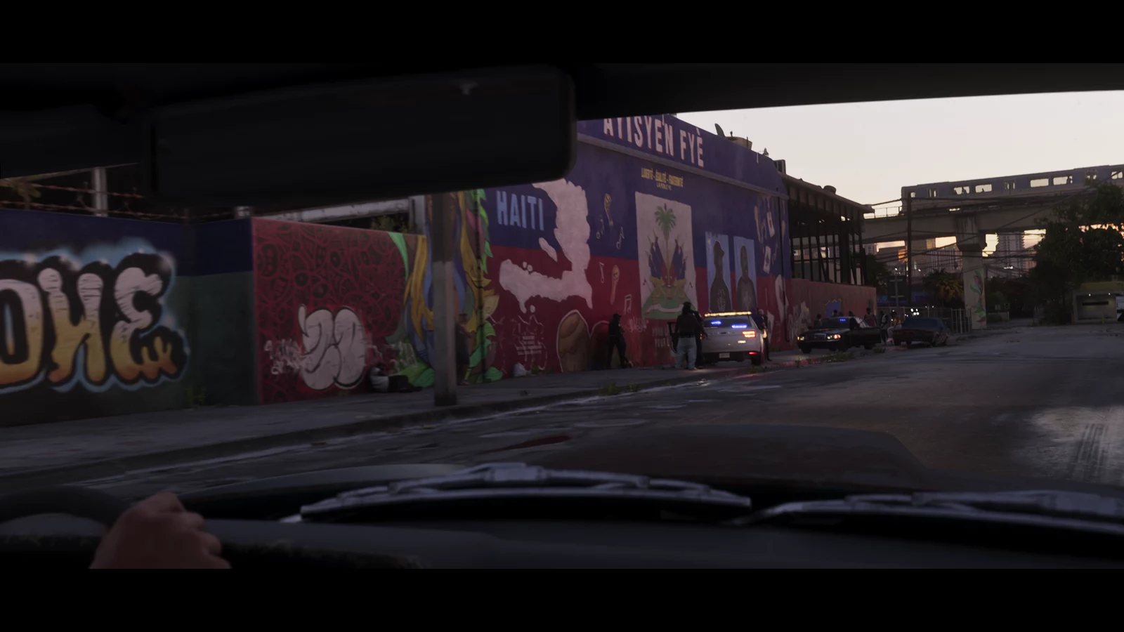 A street mural displaying Haiti and Ayisyen Fye text beside police vehicles
